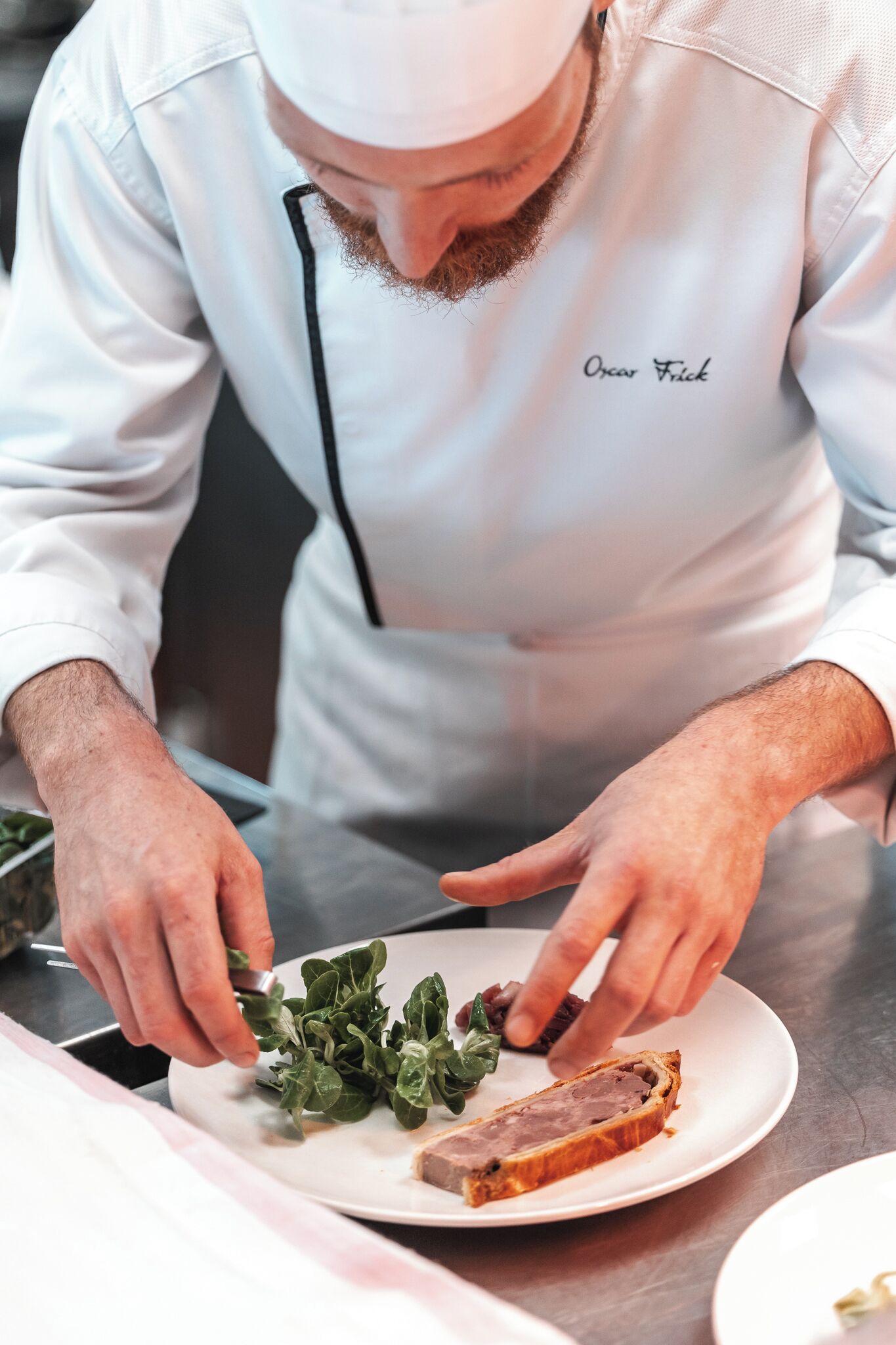 Un chef con uniforme blanco, con el nombre 