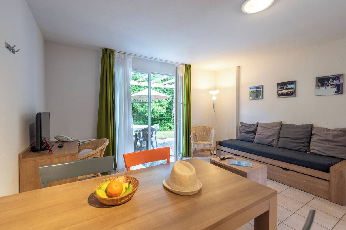 Una sala moderna con un sofá, una mesa de comedor y vistas al exterior.