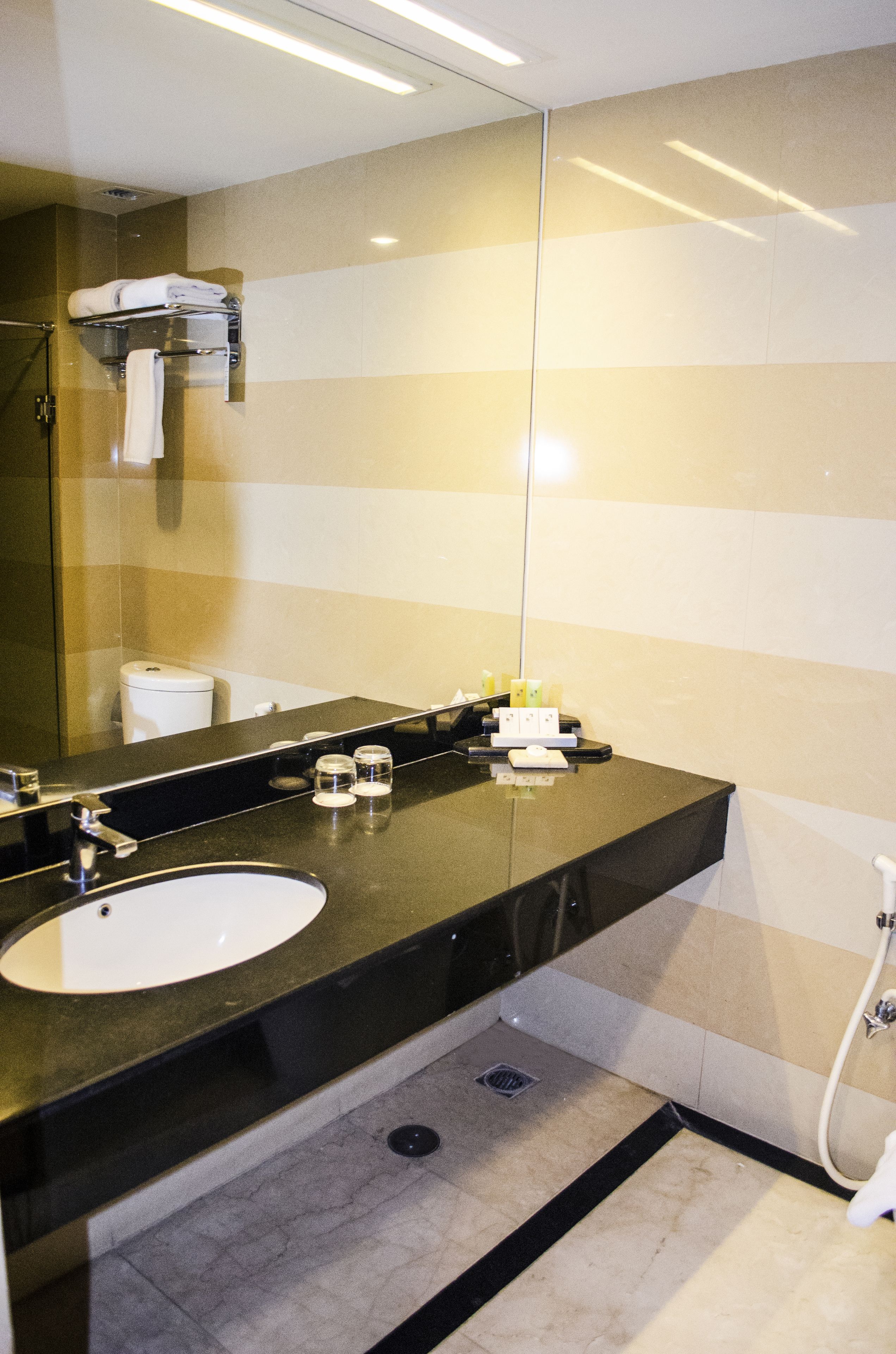 A modern bathroom with a large mirror, a sink, and a shower.