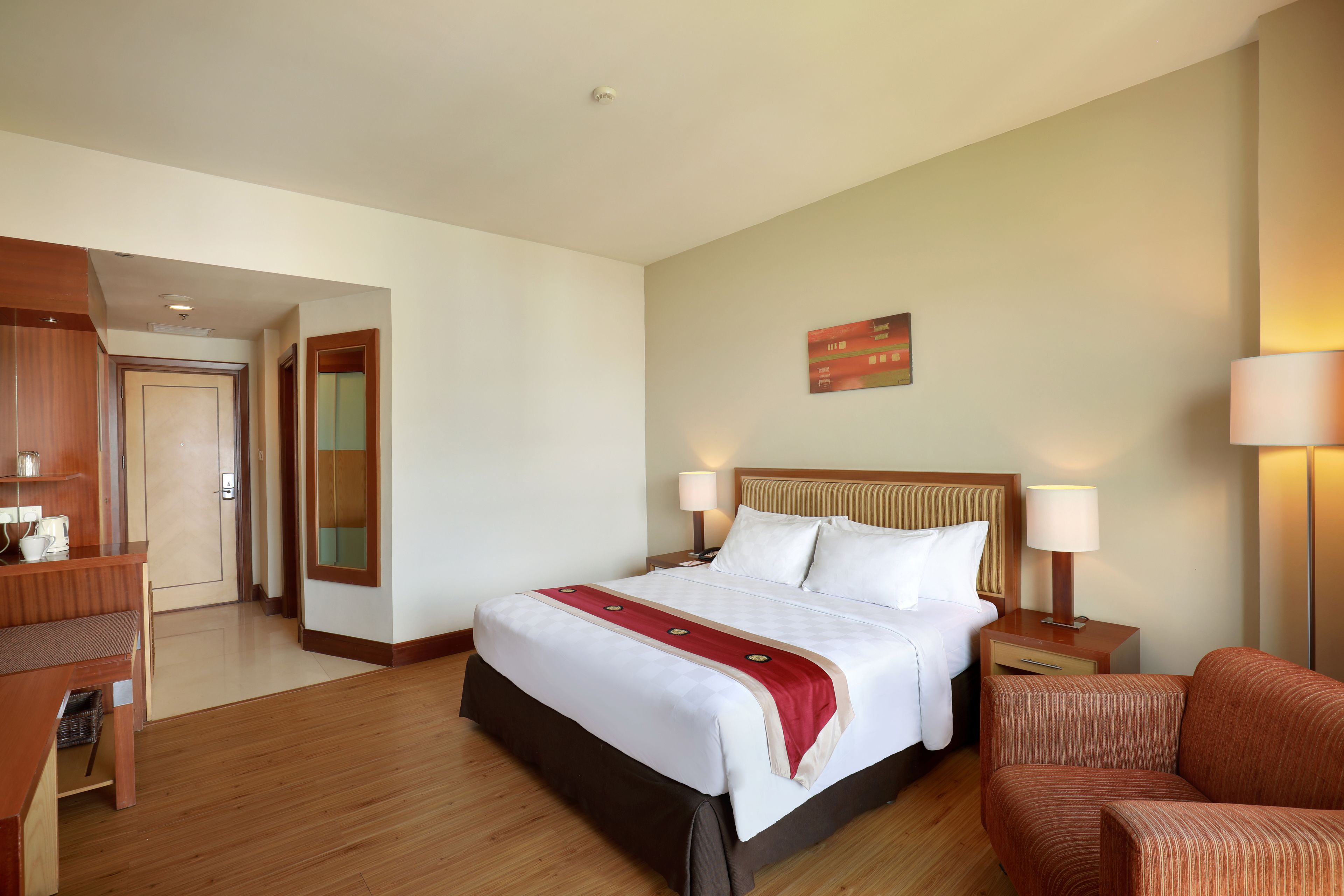 Une chambre d’hôtel avec un grand lit, des tables de chevet, un bureau et une chaise.
