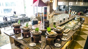 A buffet setup with various dishes and utensils.