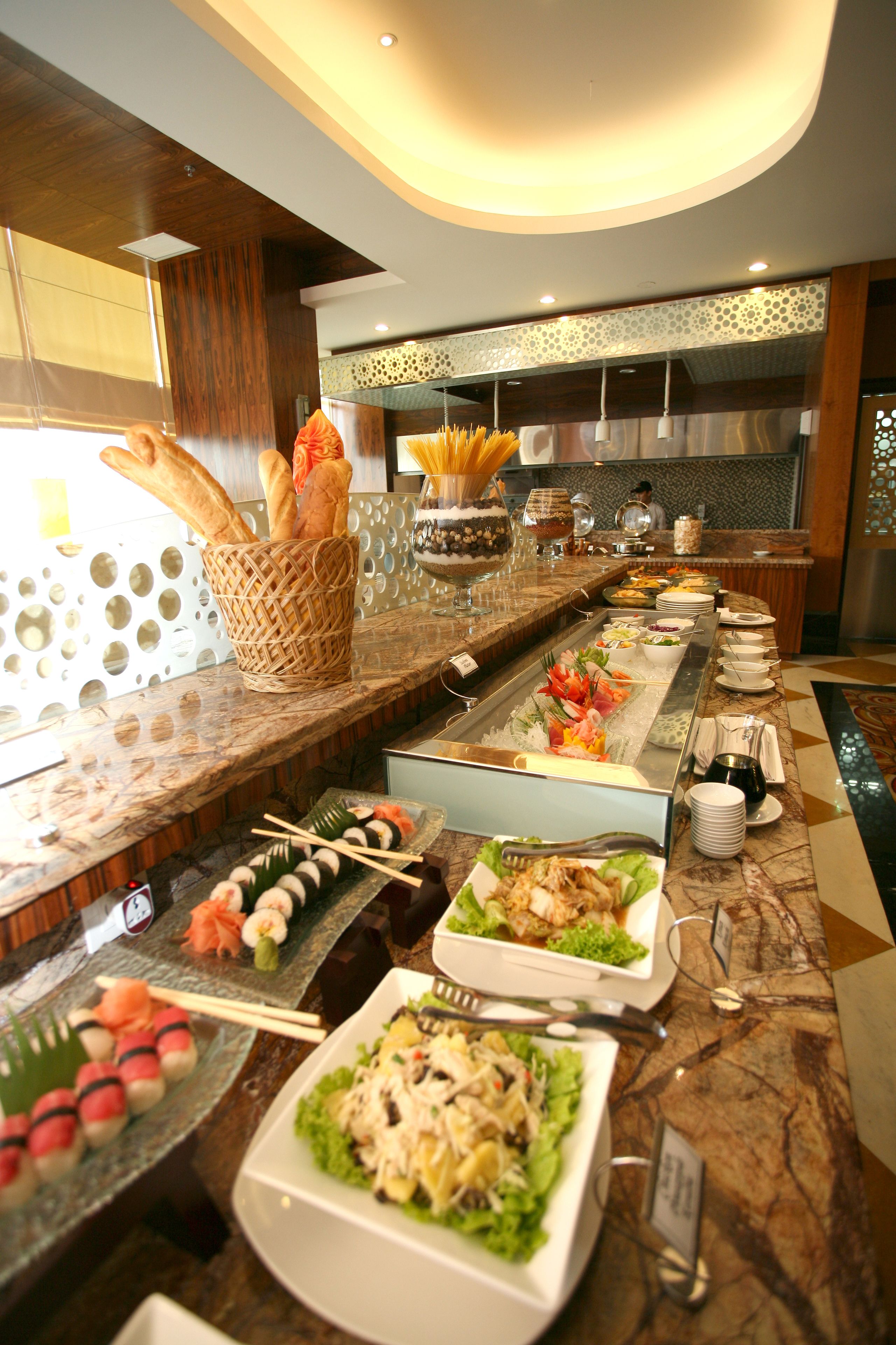 A buffet with various dishes and a basket of breadsticks.