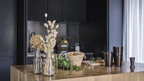 A kitchen counter with various items including glass jars, a woven basket, and kitchen utensils. - CERVO Mountain Resort (Zermatt)