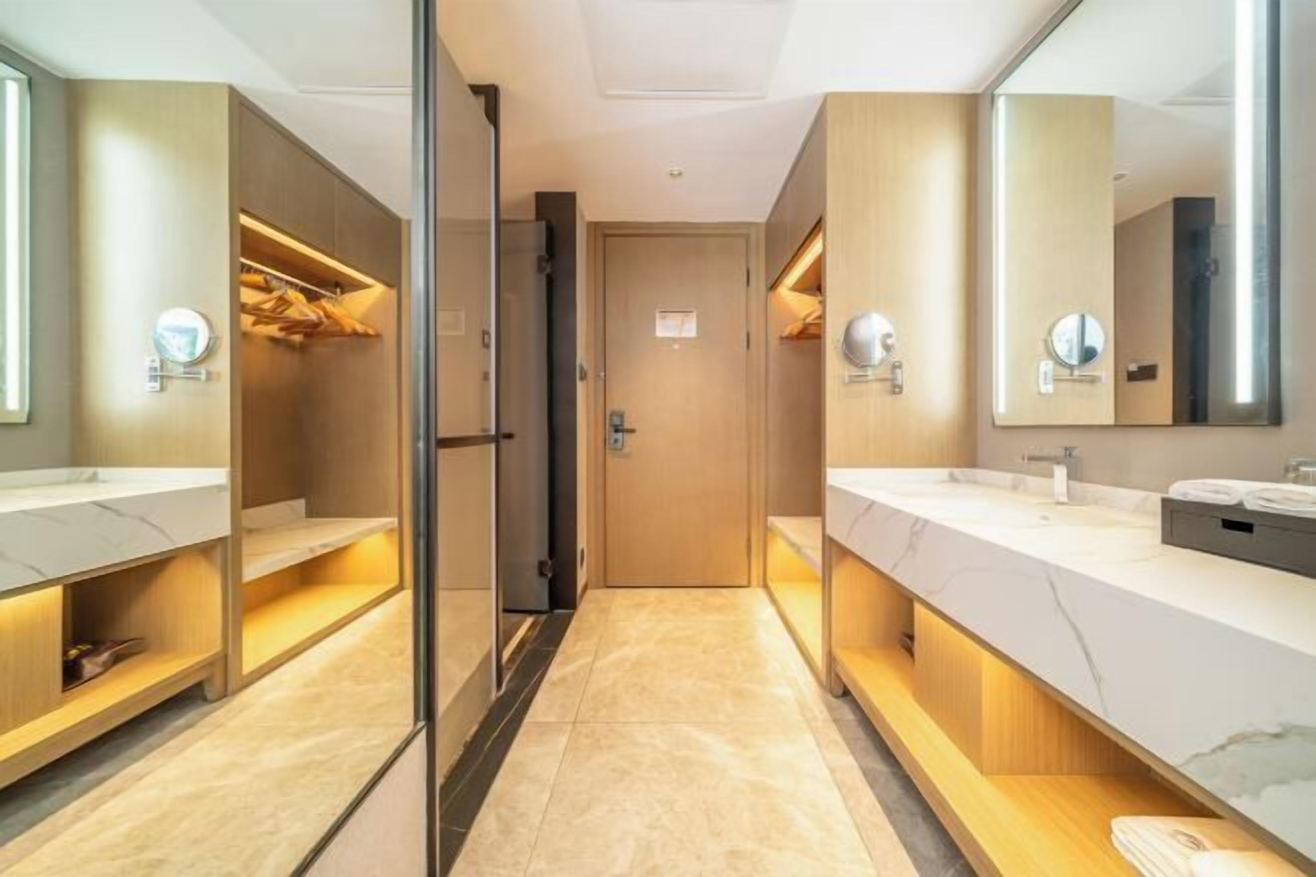 A modern bathroom with two sinks, a walk-in shower, and a mirror.