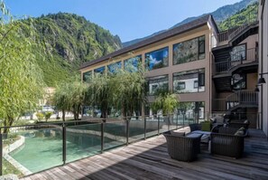 A modern hotel with a pool, outdoor seating, and mountain views. - Qianhe Rezen Hotel (Jiuzhaigou)