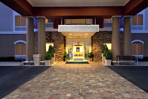 Fachada de hotel de piedra, con doble entrada y un área de recepción acogedora.