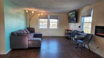 Neljän hengen deluxe-huone, 3 makuuhuonetta | Oleskelualue | 50–tuumainen televisio, jossa digitaalikanavat