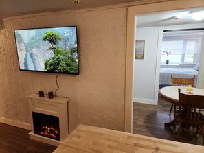 Habitación triple Deluxe, 2 habitaciones | Área de sala de estar | Televisión de 50 pulgadas con canales digitales