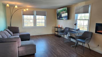 Neljän hengen deluxe-huone, 3 makuuhuonetta | Oleskelualue | 50–tuumainen televisio, jossa digitaalikanavat