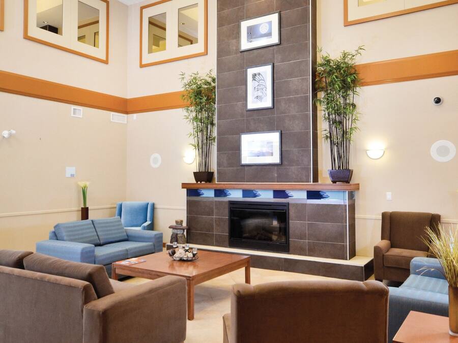 Un vestíbulo moderno con chimenea, zona de estar y espejos decorativos.