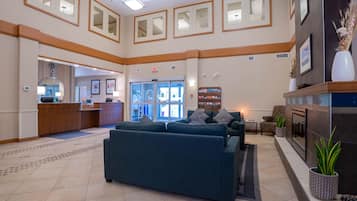 A spacious lobby with a reception desk, seating area, and a fireplace.