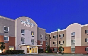 A hotel with a prominent sign reading 'CANDLEWOOD SUITES' and a well-lit entrance. - Candlewood Suites Pearland by IHG (Pearland)