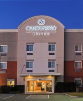 Um hotel com uma placa indicando 'CANDLEWOOD SUITES' e uma entrada visível.