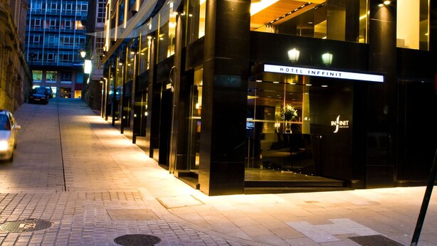 A hotel entrance with a modern facade, large windows, and a well-lit interior. - Hotel Inffinit (Vigo)