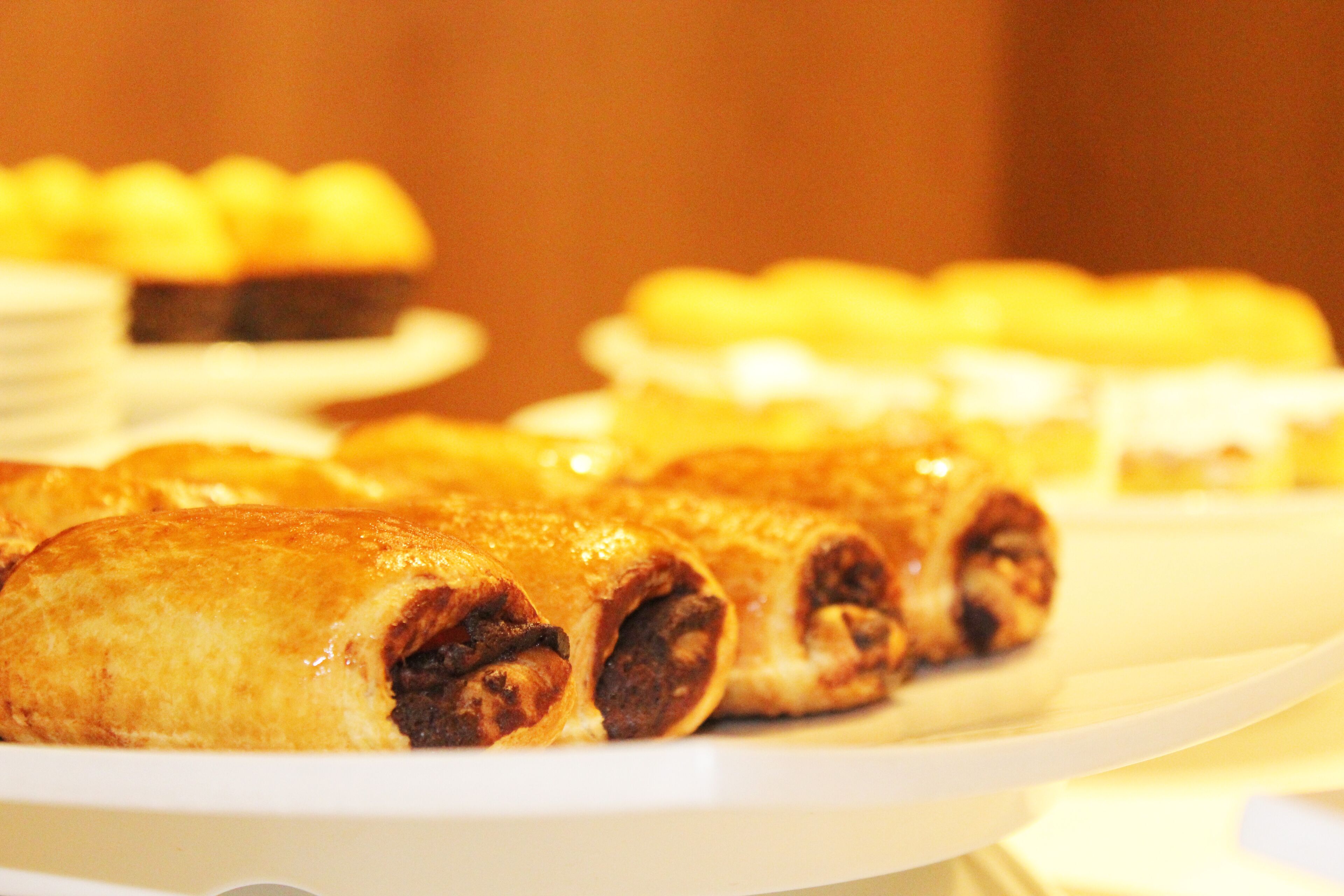 A selection of pastries on a white plate, including what appears to be a rolled dessert with a dark filling.
