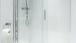 A modern shower enclosure with a glass door, a handheld showerhead, and a wall-mounted control panel. - Lancaster Court Hotel (London)