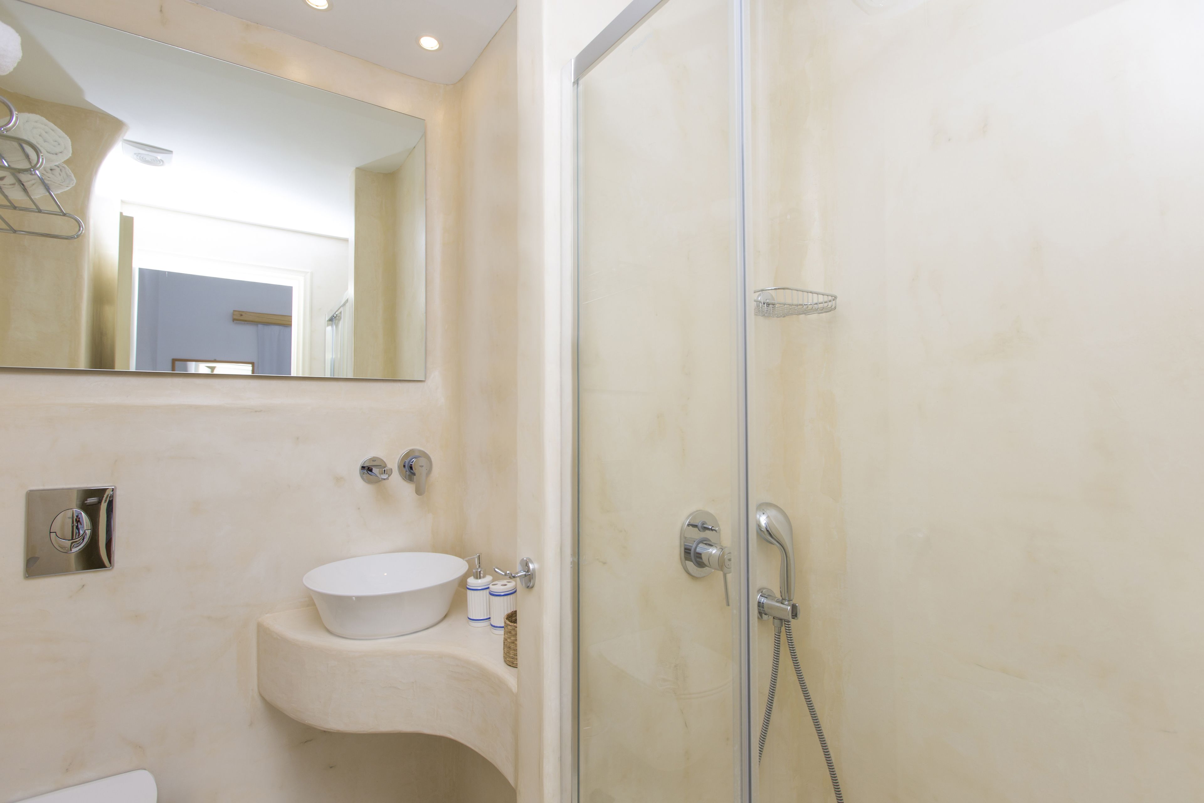 Un baño con lavabo, espejo y ducha.