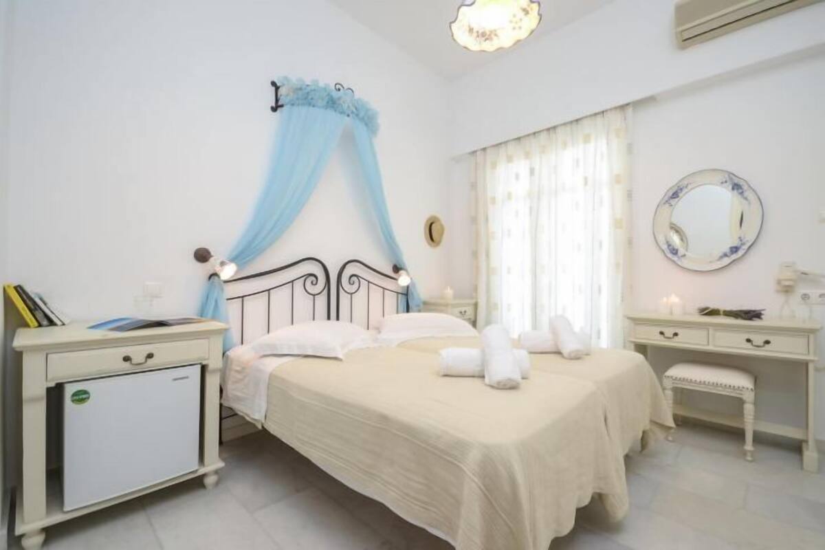 A bedroom with a bed, bedside tables, a wardrobe, and a mirror.