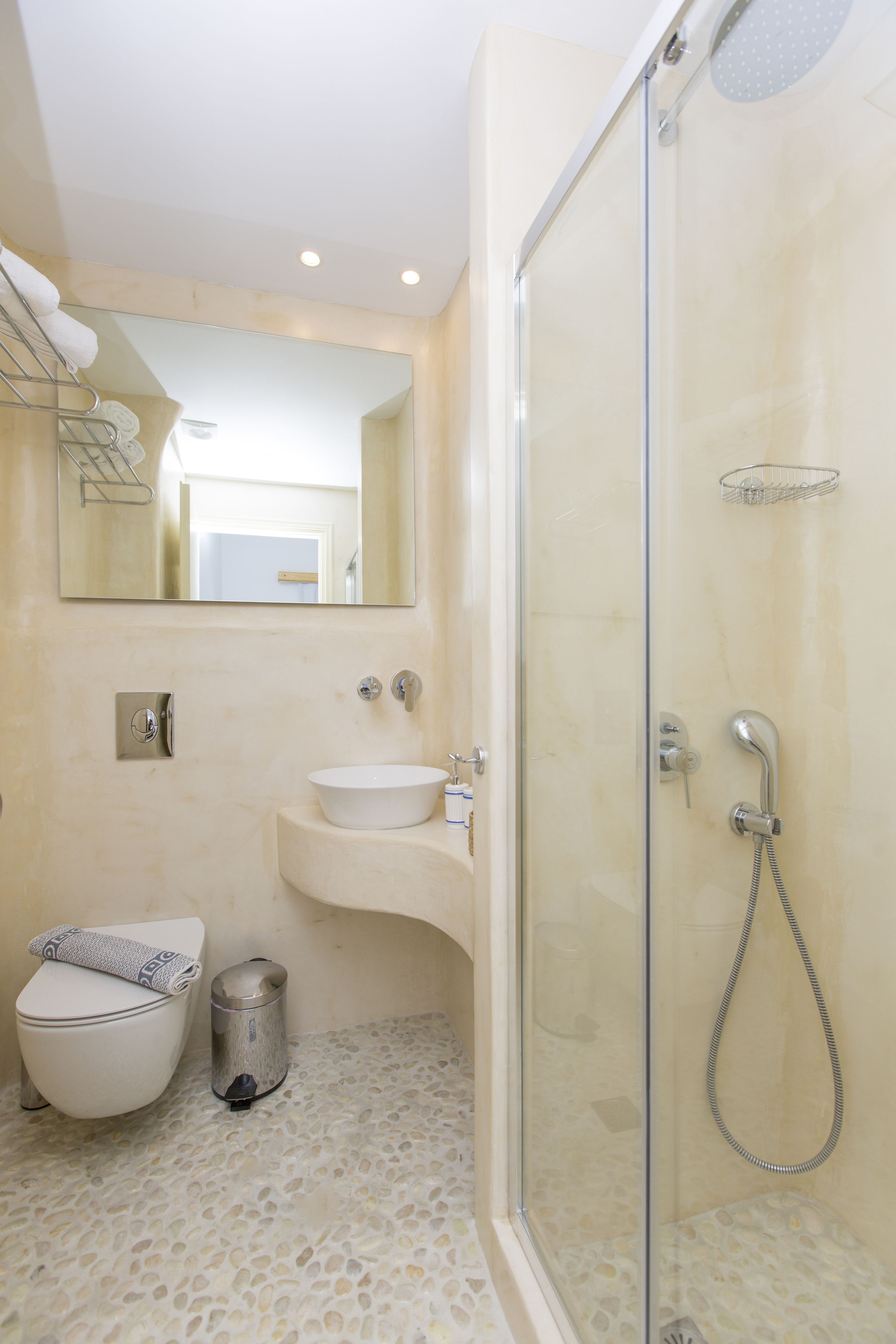 A bathroom with a toilet, sink, and shower.