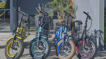 Três bicicletas estacionadas em frente a um edifício com design moderno.