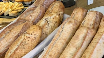 A bakery display with various types of bread and pastries.