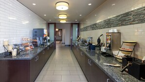 A modern kitchen with a long counter, built-in appliances, and a tiled backsplash.