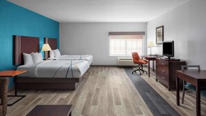 A hotel room with a bed, desk, chair, TV, and a window. - La Quinta Inn & Suites by Wyndham Woodward (Woodward)
