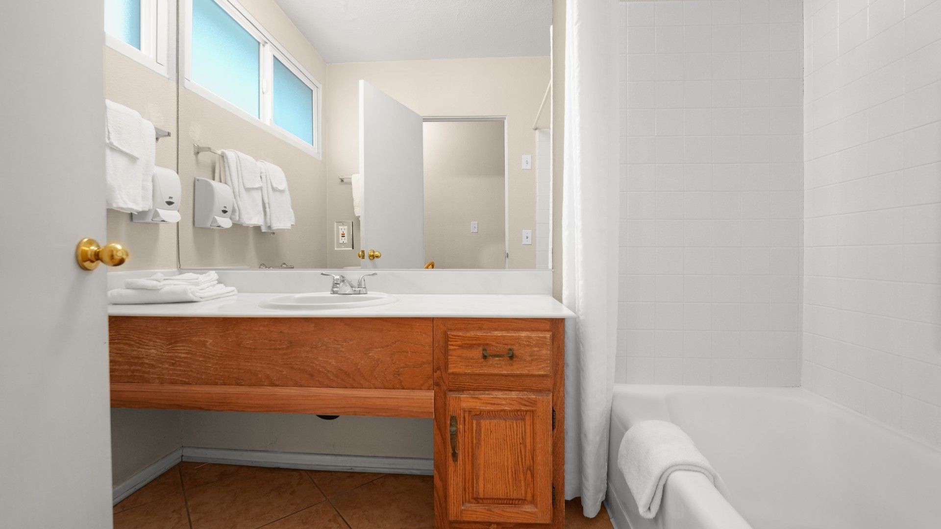 Une salle de bain avec un meuble-lavabo en bois, un évier et un miroir.