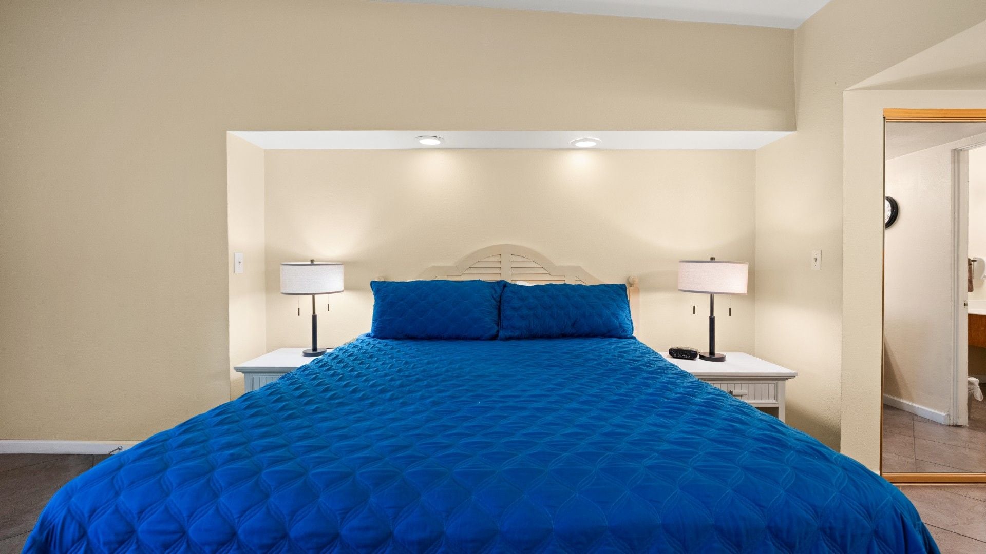 Una camera da letto con un letto, due comodini e un tavolino di appoggio.