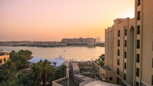 A hotel rooftop with a view of a body of water and distant buildings.