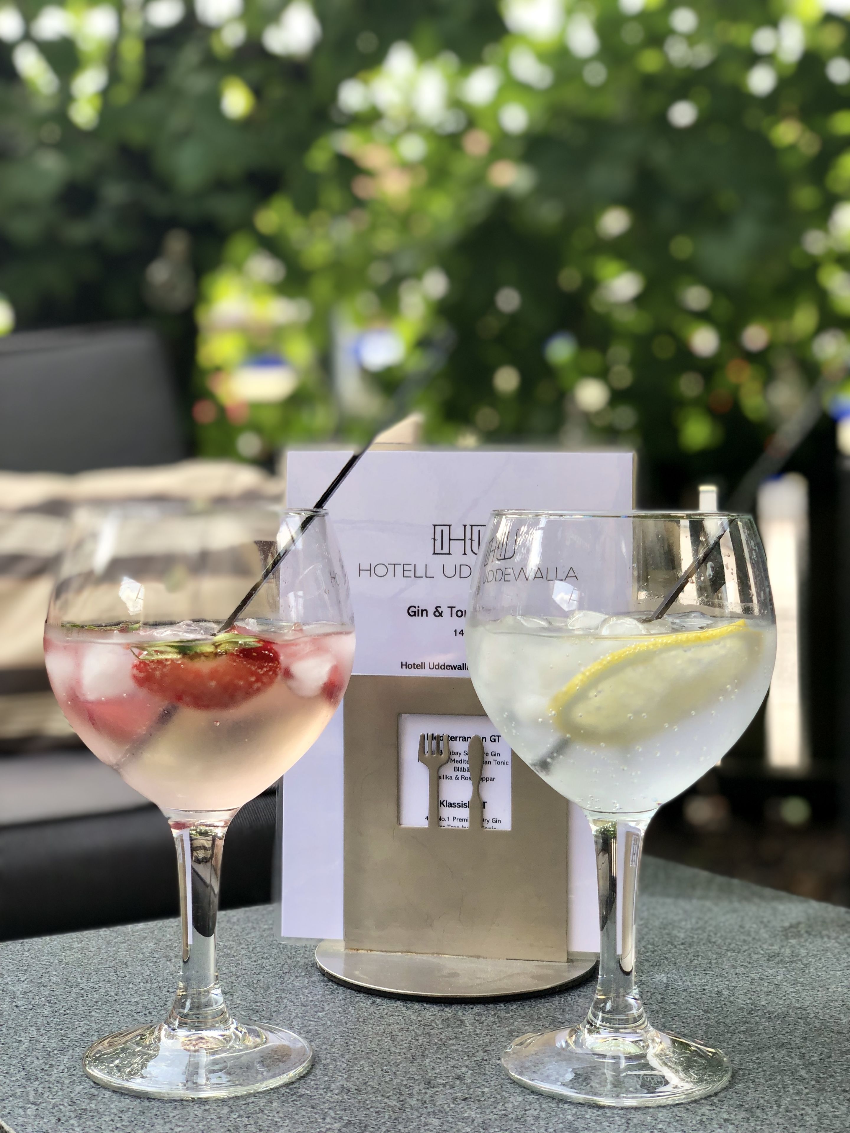 Two cocktails on a table with a menu in the background.