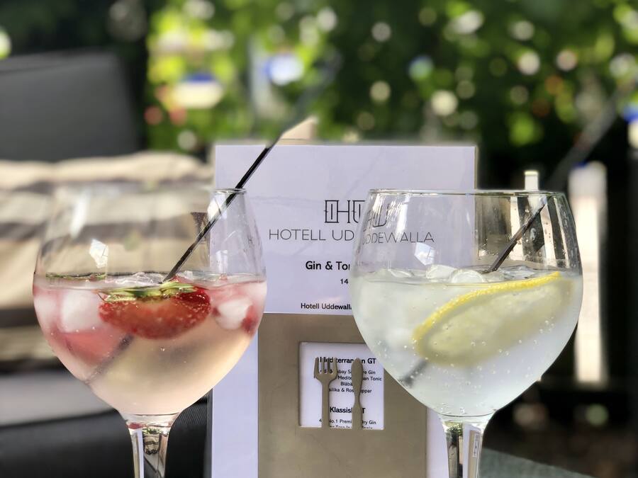 Two cocktails on a table with a menu in the background.