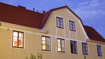 A two-story building with a red-tiled roof, multiple windows, and a beige facade.