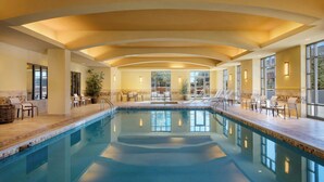 A large indoor swimming pool with multiple lounge areas, seating, and potted plants. - Courtyard by Marriott Dallas Allen at Allen Event Center (Allen)