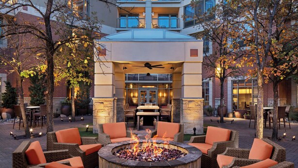 An outdoor patio with wicker furniture and a central fire pit. - Courtyard by Marriott Dallas Allen at Allen Event Center (Allen)