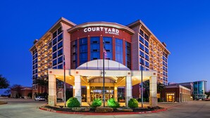 A Courtyard by Marriott hotel with a prominent entrance, multiple floors, and a well-lit facade. - Courtyard by Marriott Dallas Allen at Allen Event Center (Allen)