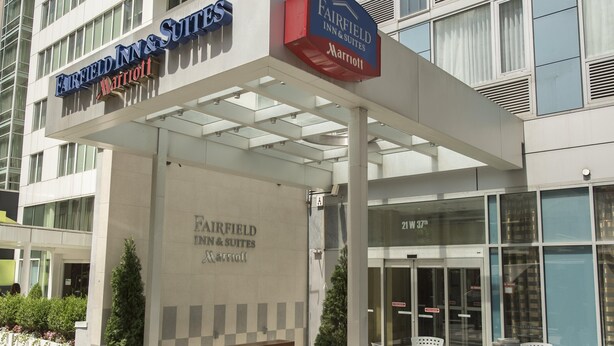 Eingang eines Fairfield Inn & Suites Marriott Hotels mit überdachter Außenbereich-Sitzgelegenheit und einer Rezeption.