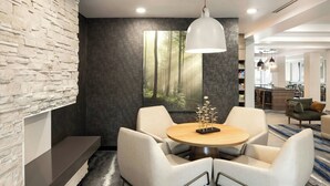 Een moderne eethoek met een ronde tafel, twee stoelen en een hanglamp.