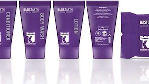 Cinco tubos morados en fila, etiquetados con diferentes productos para el cuidado de la piel de la marca BASICEARTH.