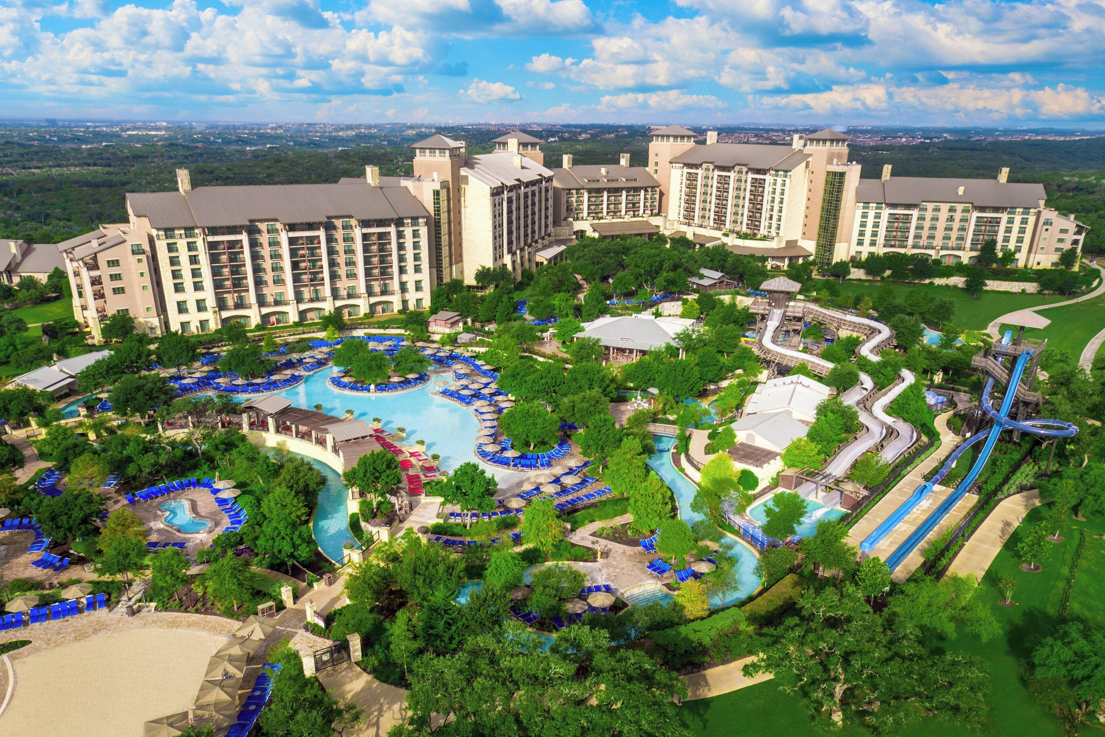 A resort with multiple swimming pools, a water park, and a large building complex.