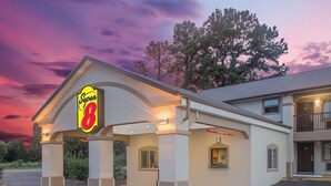 A Super 8 hotel with a covered entrance, a brick foundation, and a two-story building with a balcony. - Super 8 by Wyndham Idabel (Idabel)