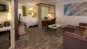 A hotel room with a bed, desk, chair, and a small table with apples. There is a microwave, a refrigerator, and a painting on the wall. - SpringHill Suites Anchorage University Lake (Anchorage)