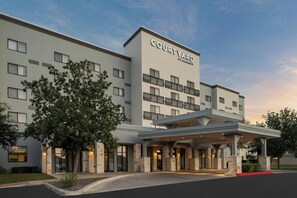 Un hôtel Courtyard by Marriott doté d’une façade moderne, de nombreux balcons et d’une entrée abritée.