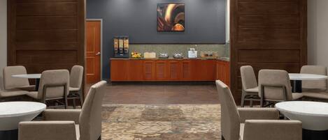 A hotel lobby with a reception desk, seating area, and a patterned carpet.