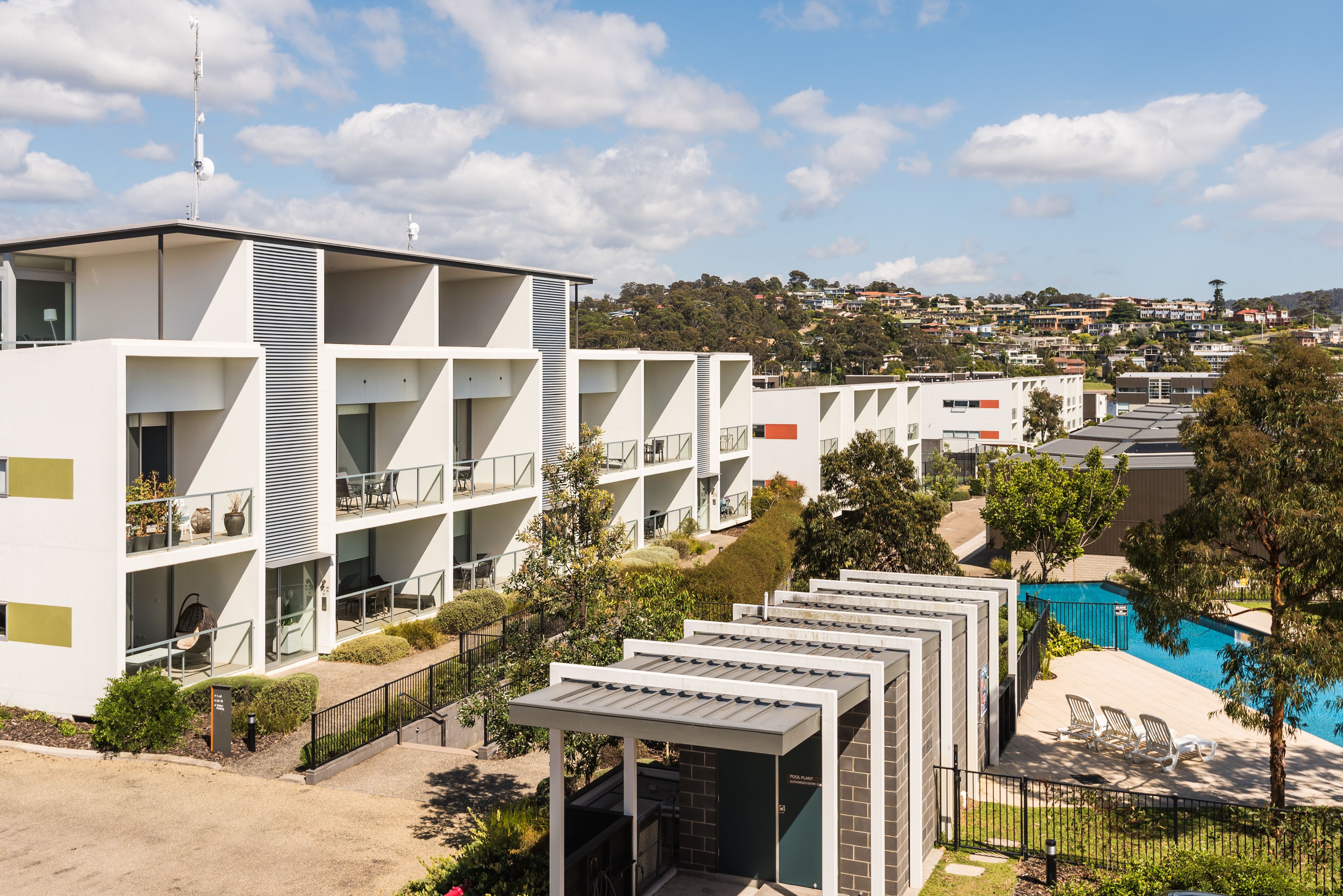 Un hôtel moderne doté de plusieurs étages, d’une terrasse et d’une piscine.