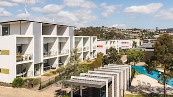 Un hôtel moderne doté de plusieurs étages, d’une terrasse et d’une piscine.