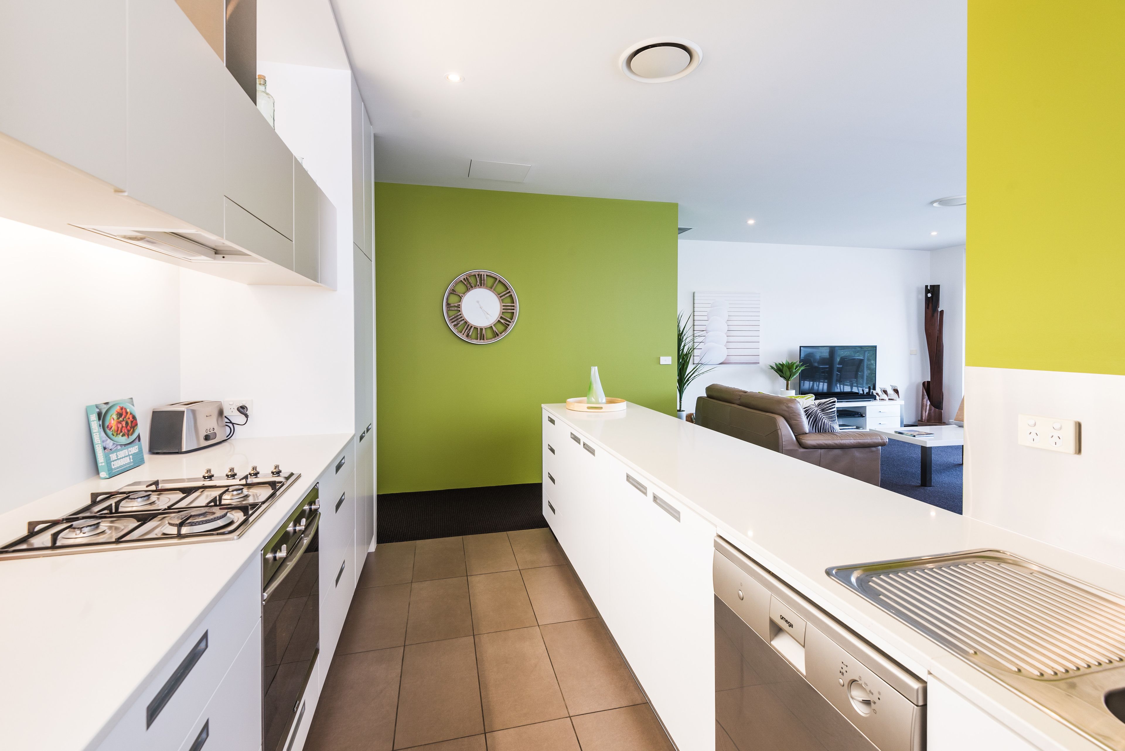 A modern kitchen with white cabinets, a gas stove, and a dishwasher.