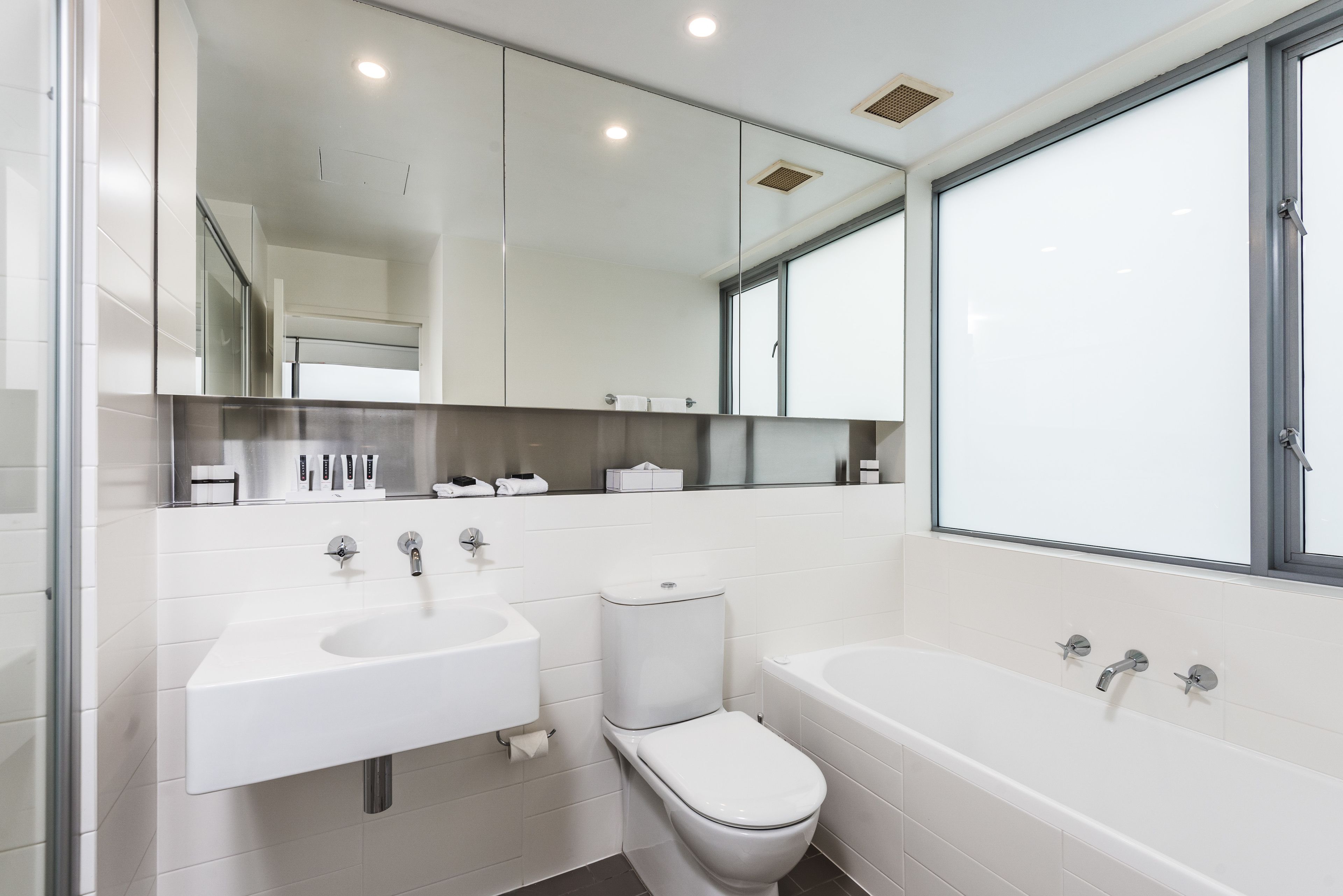 A modern bathroom with a toilet, sink, and bathtub.