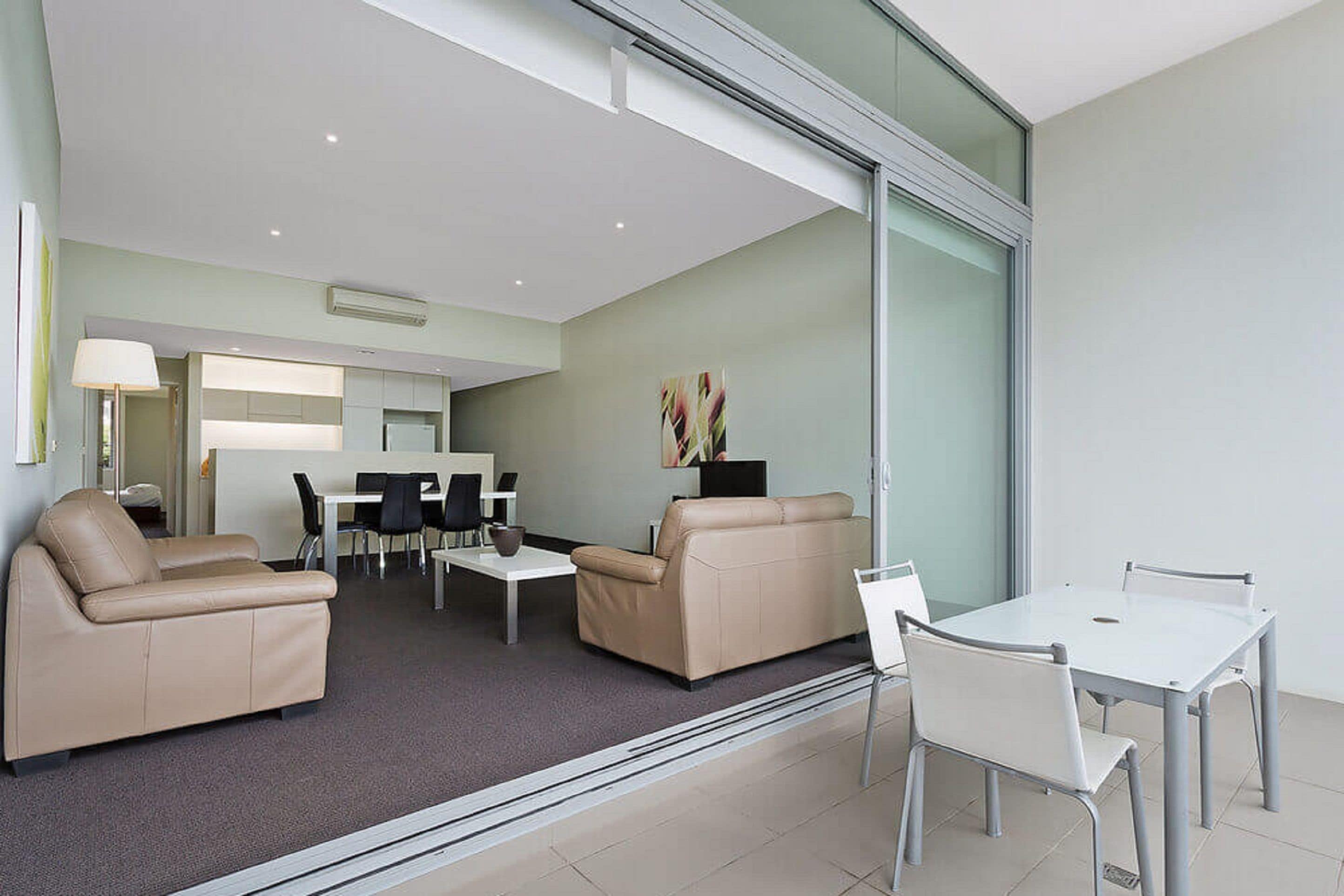 A modern living room with a sofa, coffee table, and dining area.
