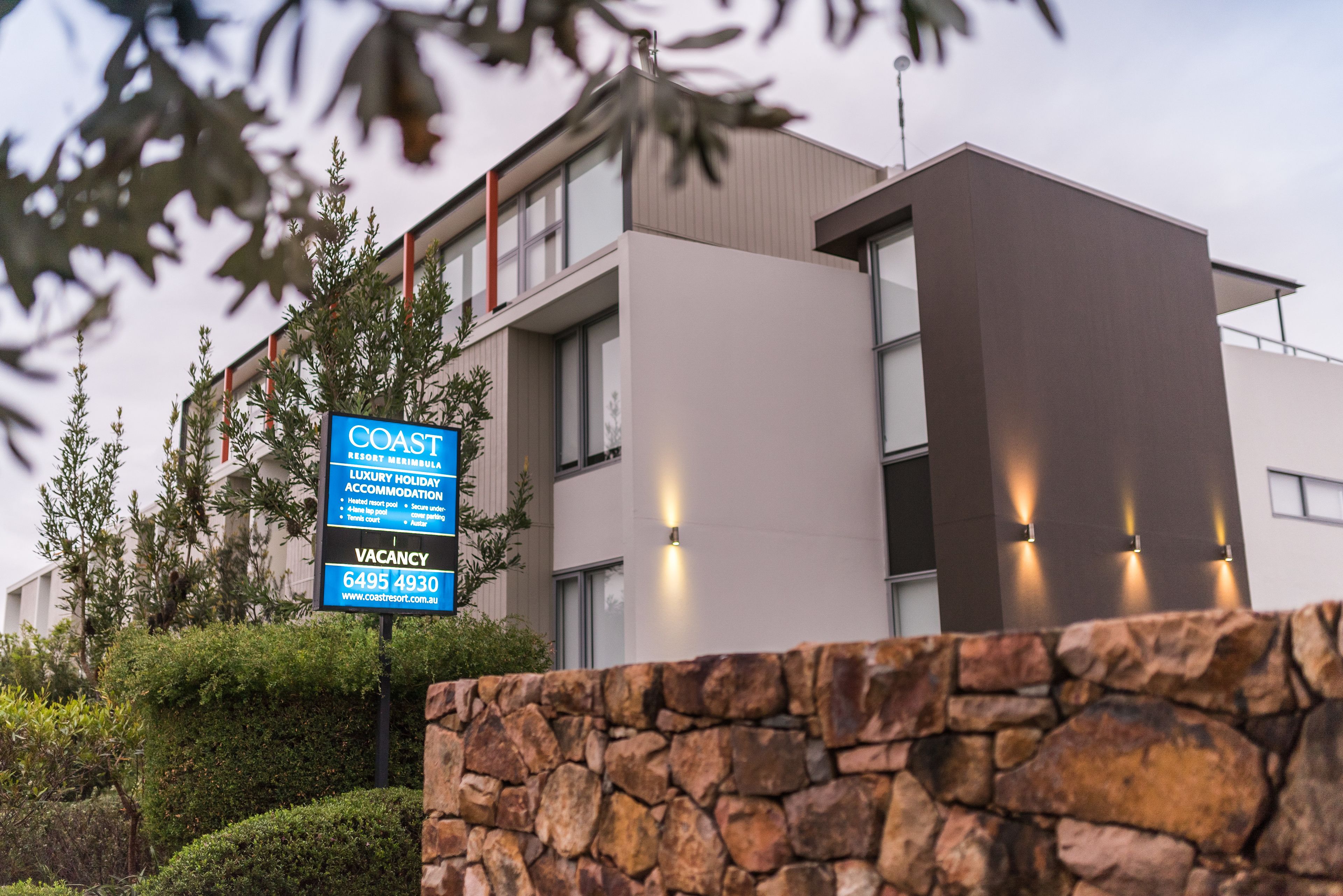 A modern building with a sign indicating a vacancy for a luxury holiday accommodation.
